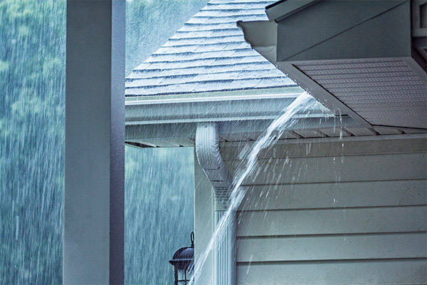 Water flowing off the edge of a roof during a storm