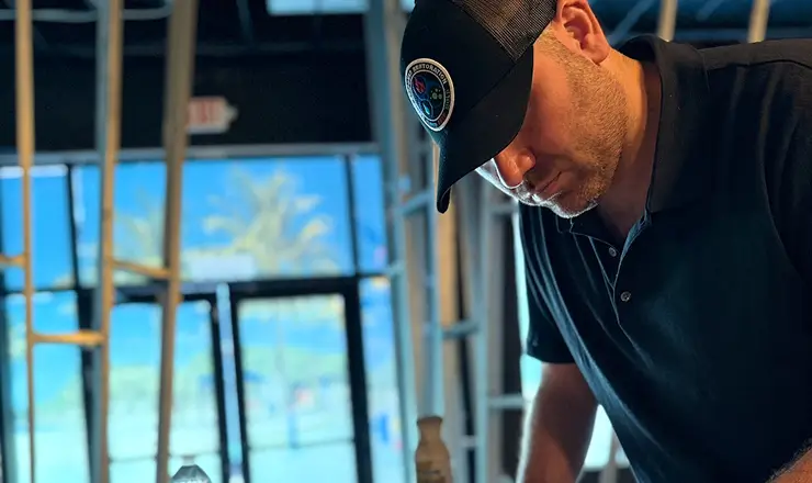 Restoration technician working on site reflected in glass